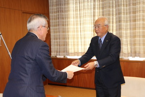 田中代表取締役（写真右）から開設表明書を受け取る奥塚市長