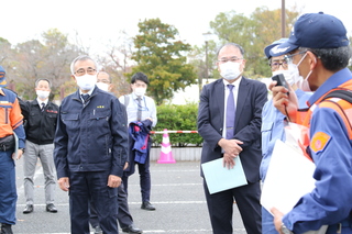 ダイハツ九州スポーツパーク大貞で説明を聞く奥塚市長（写真左）