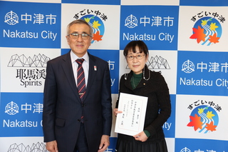 記念写真（写真左が奥塚市長、右が本田さん）