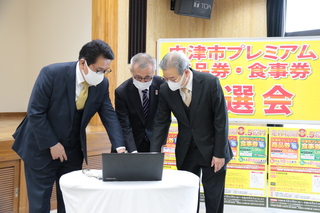 抽選ボタンを押す奥塚市長（写真中央）